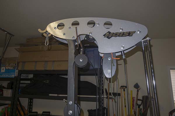 Photograph of Hoist V5 home gym, during assembly, with two pulleys supported in place with string.